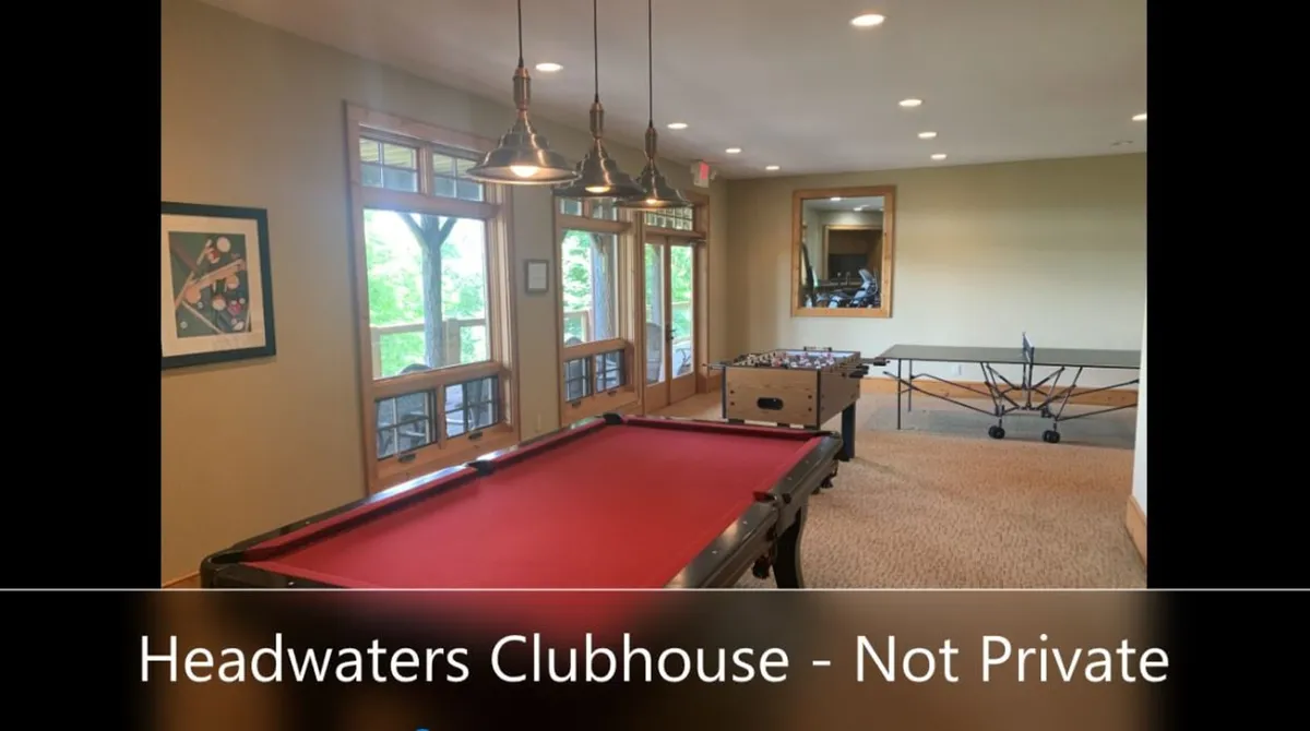 A bright game room with a pool table, foosball table, ping pong table, and large windows that bring in ample natural light. The space is lively and designed for group fun and social gatherings, perfect for families or friends to unwind after outdoor exploration.